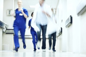 Blurred image of doctors running down a hospital corridor in an emergency