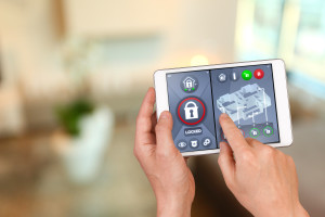 Smart home automation: apartment interior with hand pointing an interactive tablet display showing house automatic locking system, with safety icons and symbols and unlocking functions.